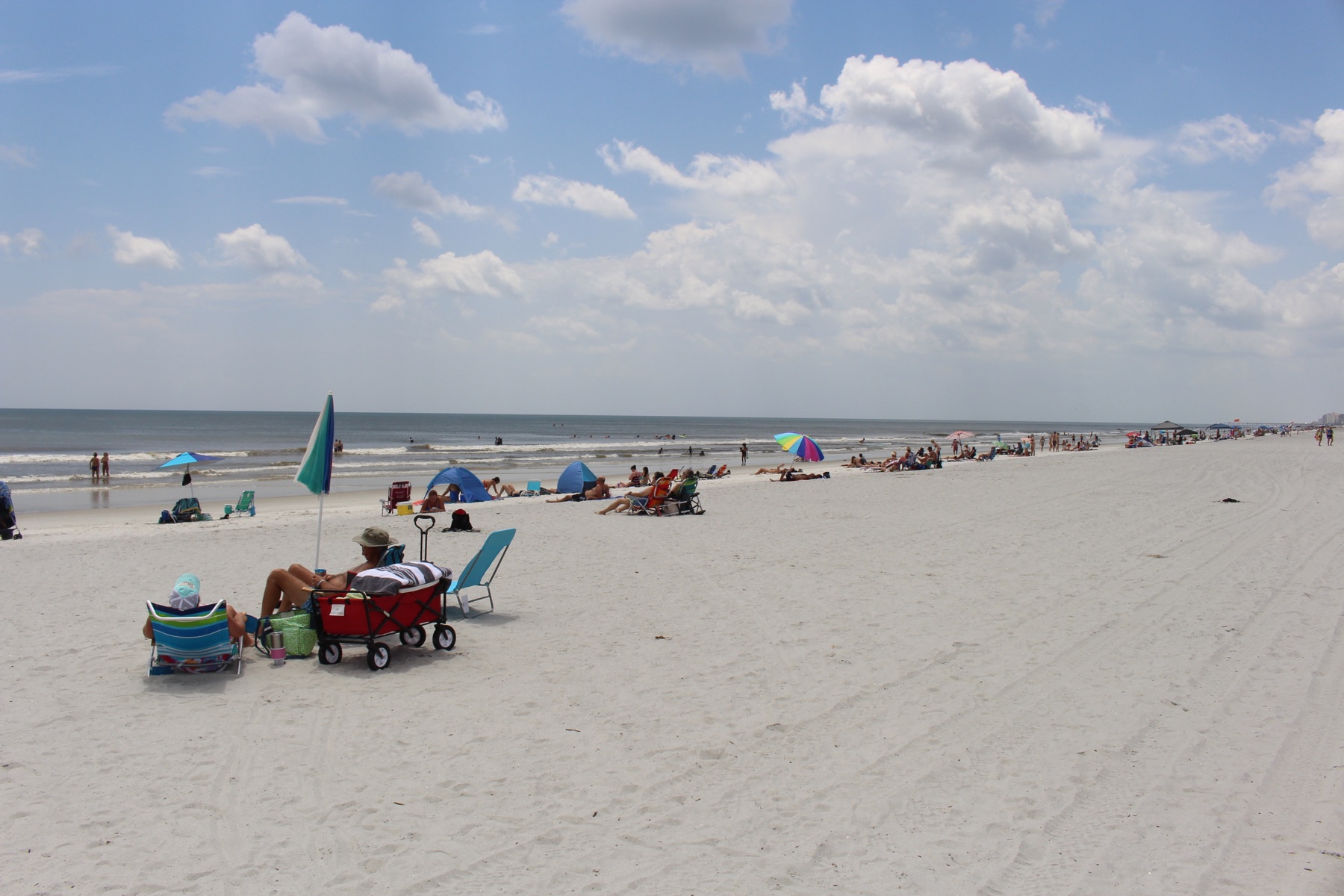 Beachgoers along the wide shoreline at Neptune Beach Florida